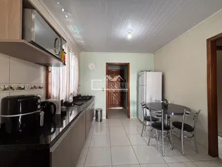 Cozinha com armários e mesa de jantar em um imóvel no Brasil.