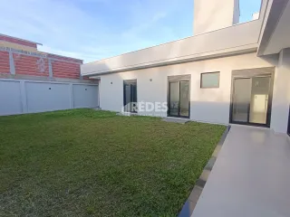 Fachada de uma residência moderna com jardim verde.