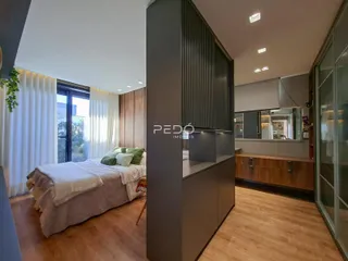 Quarto com piso de madeira e janela.