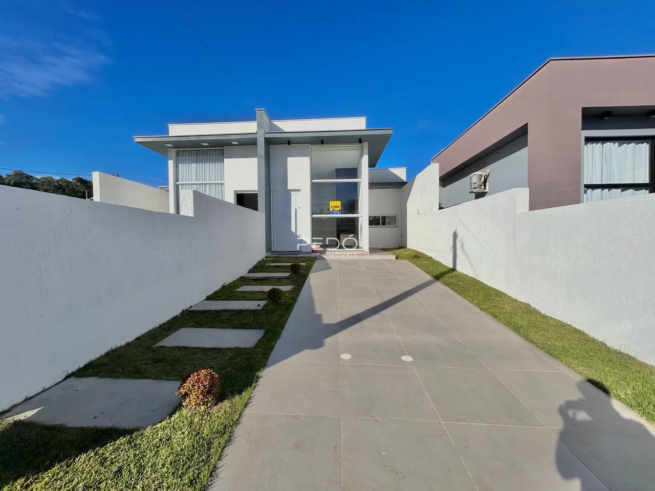 Fachada de uma residência moderna em Lajeado, Brasil, com jardim frontal.