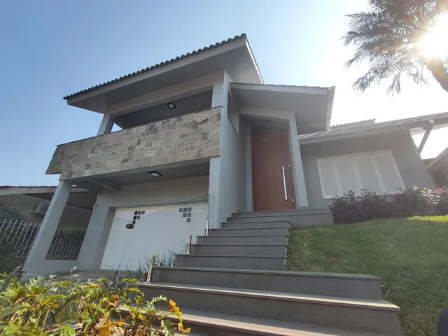 Fachada de uma casa moderna com garagem e jardim em Lajeado.