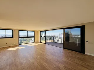 Sala de estar com piso de madeira e vista da cidade.