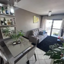 Foto interna de uma sala de estar com sofá e decoração.