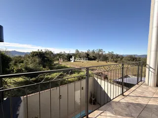 Vista de uma paisagem rural com vegetação e colinas.