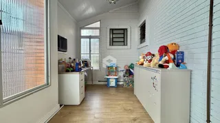 Ambiente interno de uma sala com paredes de tijolo branco e piso de madeira clara.
