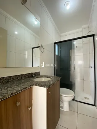 Foto de um banheiro com revestimento branco e bancada de granito.
