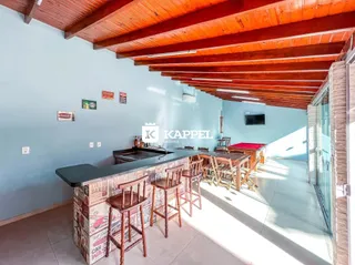 Foto de uma cozinha com balcão e mesa de jantar em um ambiente com teto de madeira.