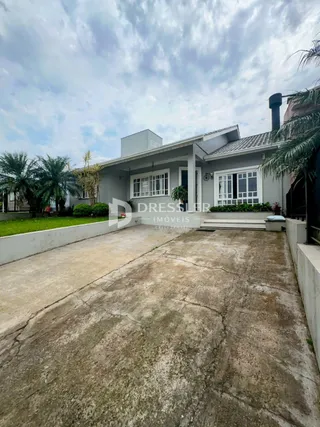 Fachada de uma residência em Lajeado, Brasil, com entrada de garagem e jardim.