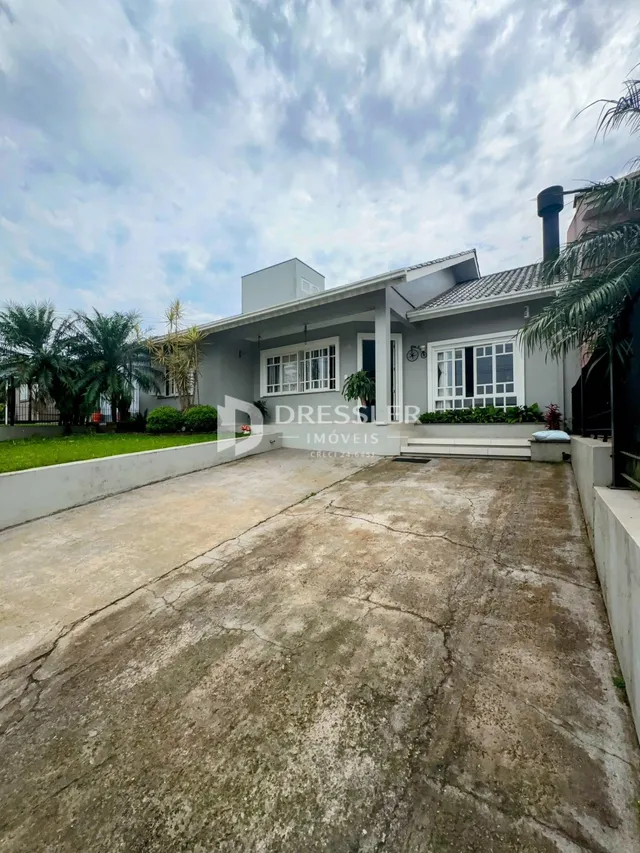 Fachada de uma residência em Lajeado, Brasil, com entrada de garagem e jardim.