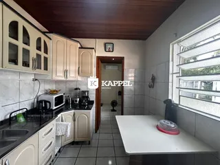 Foto de uma cozinha com armários brancos e piso de cerâmica.