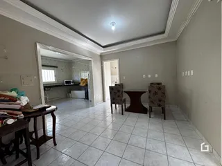 Sala de jantar com piso de cerâmica e espelho na residência.
