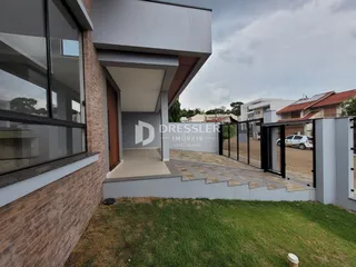 Fachada moderna de uma residência em Lajeado, Brasil, com área externa pavimentada.