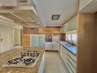 Vista da cozinha moderna com armários e bancadas de granito.