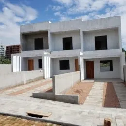 Fachada de uma casa moderna em Lajeado, Brasil, com paredes brancas e detalhes em cinza.