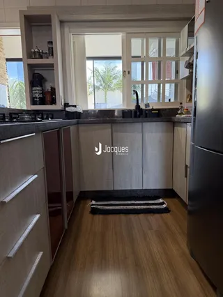 Cozinha moderna com armários de madeira e piso de madeira clara.