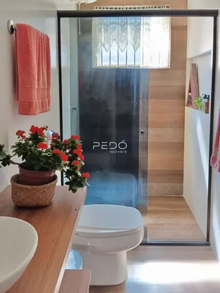 Foto de um banheiro interno com porta de vidro e toalha pendurada.