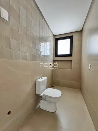 Um corredor com revestimento de azulejo e um vaso sanitário.