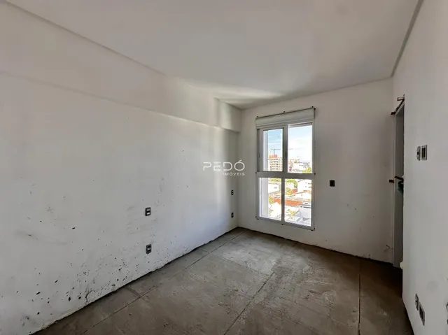 Foto de um ambiente interno com paredes brancas e piso de concreto.