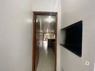 Vista de um corredor interno com portas de madeira.