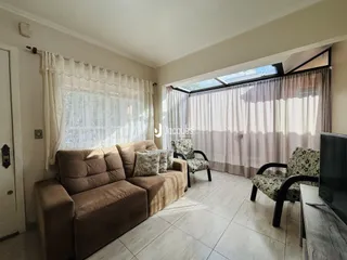 Sala de estar com sofá e cadeiras em um imóvel no Brasil.