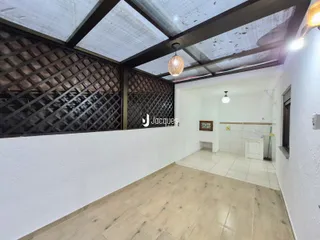 Ambiente interno com teto de vigas expostas e piso de porcelanato claro.