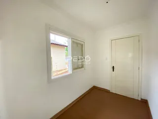 Vista interna de um cômodo com janela e porta branca.