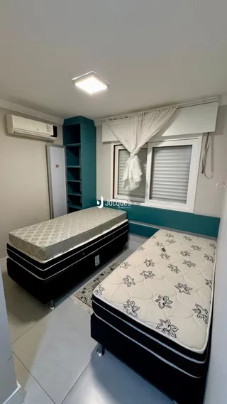 Quarto com cama e estante azul em um imóvel.