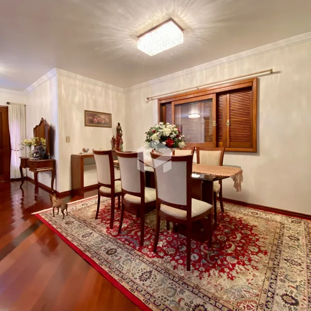 Uma sala de jantar com móveis de madeira e tapete no interior da casa.