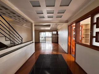 Hall de entrada com piso de madeira e escadaria.