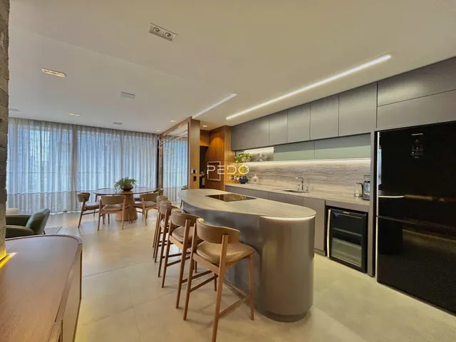 Interior moderno de uma sala de estar com cozinha aberta em Lajeado.