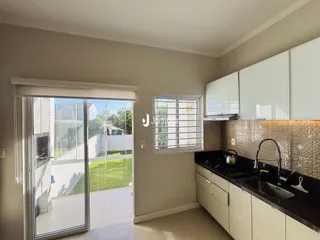 A cozinha e a sala de jantar abrem para uma área externa com vista para o jardim.