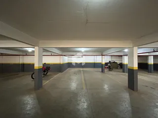 Espaço aberto com colunas de concreto em uma área de estacionamento.