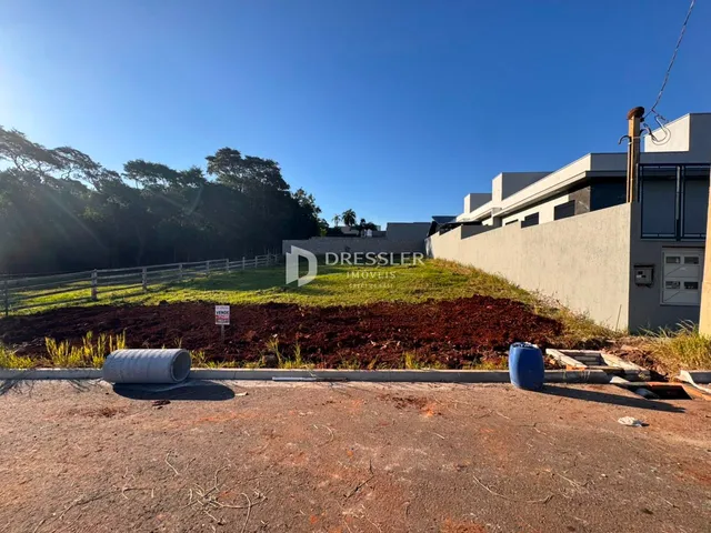 Vista externa de uma propriedade com área gramada e construção moderna.