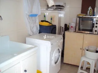Foto de um banheiro com máquina de lavar roupa branca.