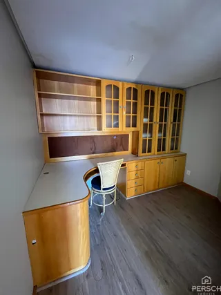 Quarto com armários de madeira embutidos na parede.