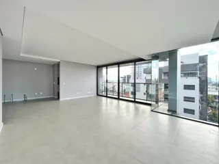 Ambiente interno amplo com piso claro e portas de vidro.