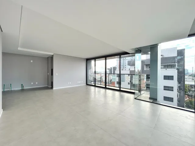 Ambiente interno amplo com piso claro e portas de vidro.