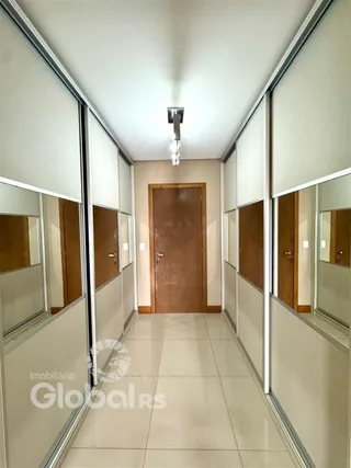 Corredor interno de um imóvel com portas espelhadas.