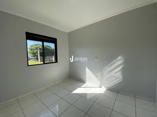 Vista interna de uma sala com piso de cerâmica e janela.