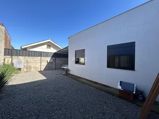 Fachada externa de uma residência em Lajeado, Brasil, com jardim de cascalho.