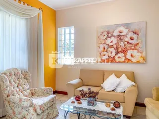 Sala de estar com sofá e poltrona decorada em um ambiente claro.