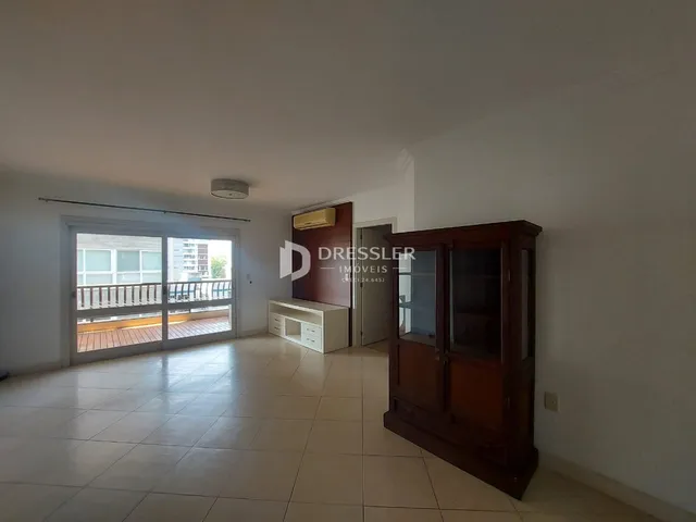 Sala de estar com portas de vidro abrindo para uma varanda.