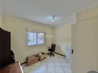 Interior de uma sala com piso de cerâmica e janela.