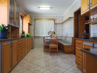 Interior de uma sala de jantar com armários de madeira e piso de cerâmica.