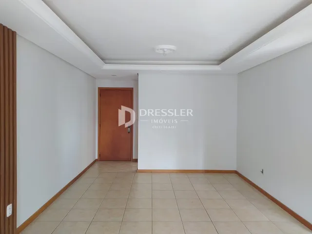 Hall de entrada com piso de cerâmica e porta de madeira.