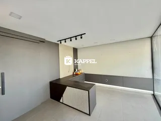 Vista de uma cozinha moderna com bancada escura e painel de madeira.
