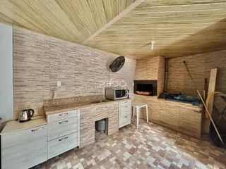 Interior de uma cozinha com paredes de azulejo e teto inclinado.