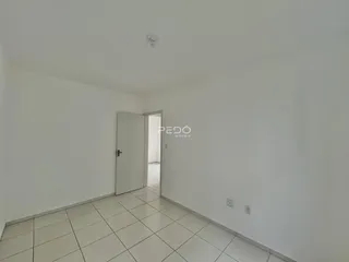 Hall de entrada com paredes brancas e piso de cerâmica clara.