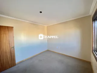 Esta é uma sala de estar com piso de carpete cinza e paredes claras.