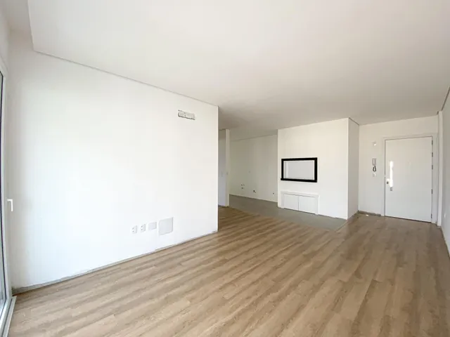 Hall de entrada com piso de madeira clara e paredes brancas.